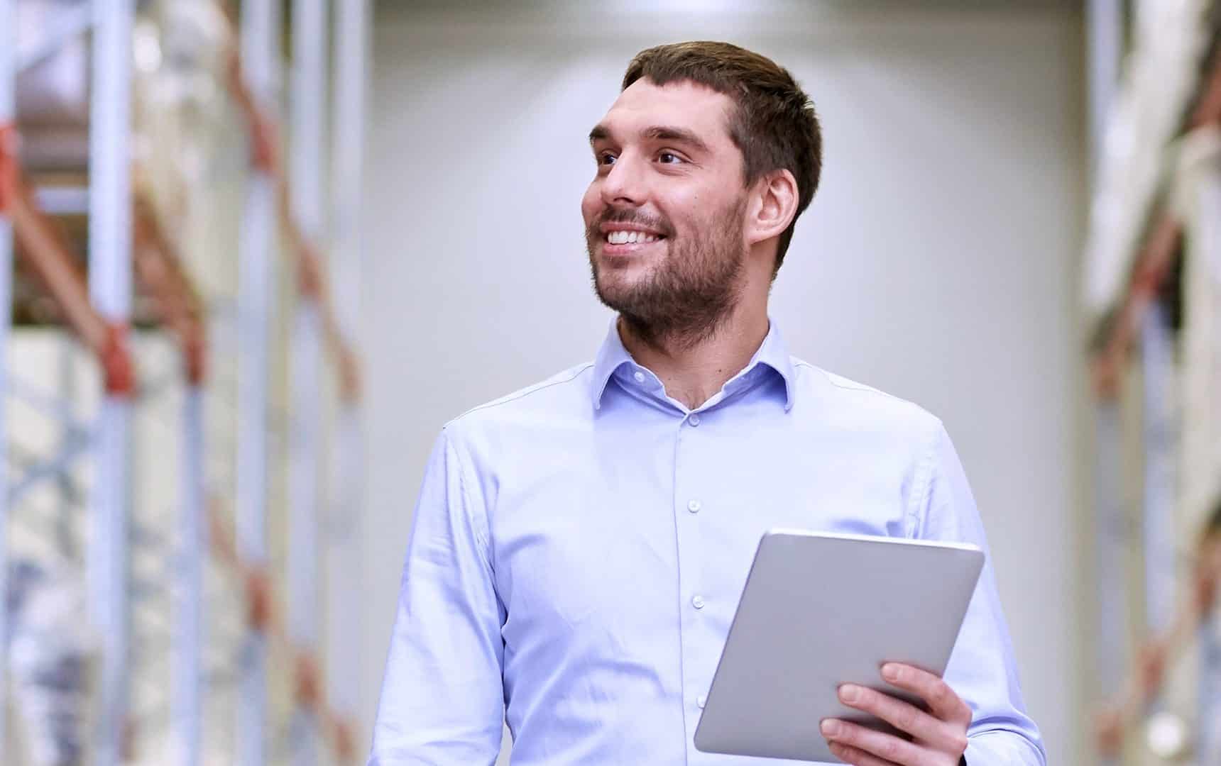 Man smiles while looking away from tablet