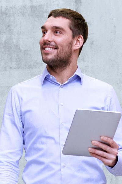 Man smiling looking away from tablet