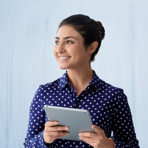 Woman smiling, looking away from tablet