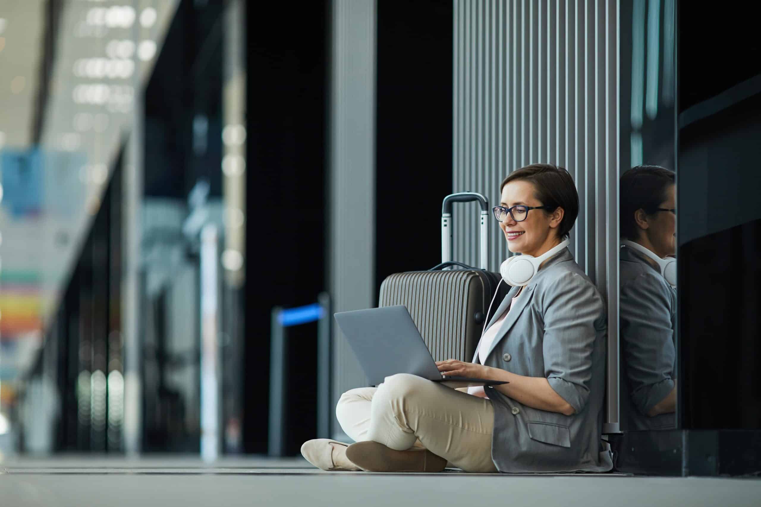 Woman sitting at the airport busy in her laptop